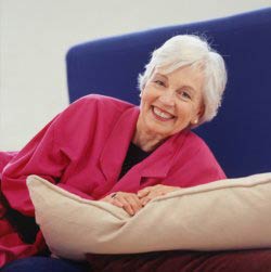 a senior on a sofa smiling